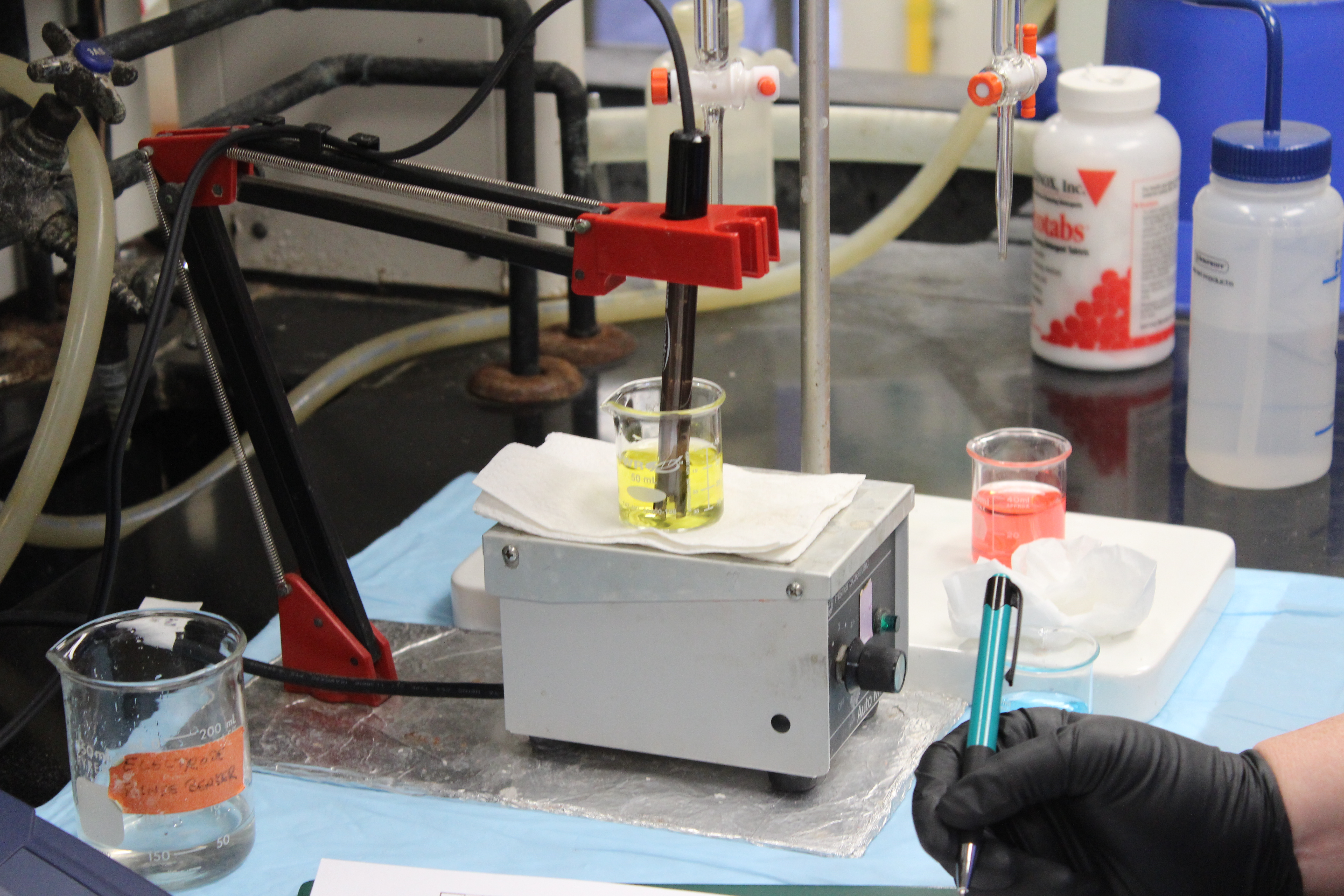 the wastewater analysis lab testing a yellow fluid in a beaker